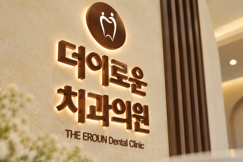 따뜻한 자연광이 비치는 더이로운치과의원 내부 간판과 목재 루버 공간 사진