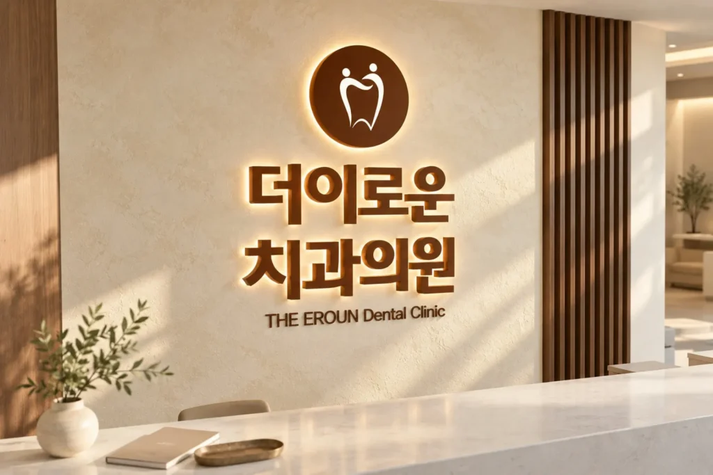 자연광이 비치는 더이로운치과의원 로고 벽면과 소품이 놓인 리셉션 카운터를 위에서 내려다본 사진