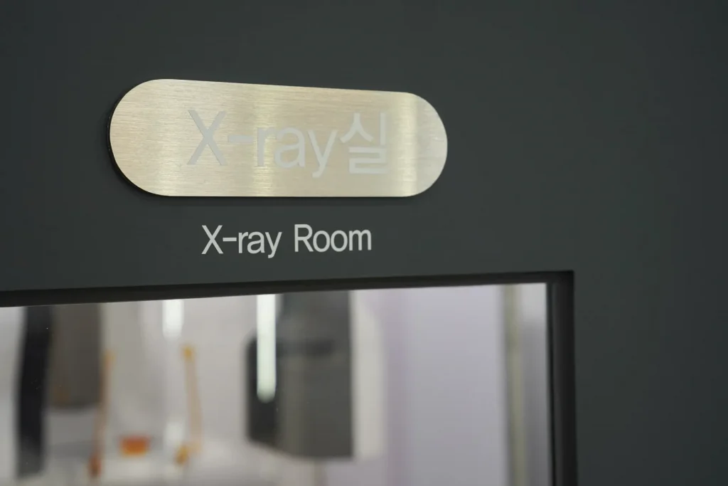 더이로운치과의원 X-ray 촬영실 출입구와 안내 사인